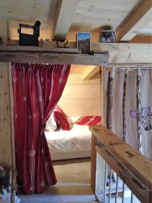 a room with a bed in a wooden room at Les Chalets du Bonheur in Les Houches