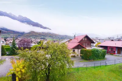 a village with a red roofed house and a mountain at Appartement Very - Welkeys in Sallanches