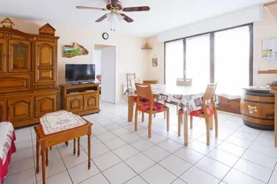 a living room with a dining room table and chairs at Appartement Very - Welkeys in Sallanches