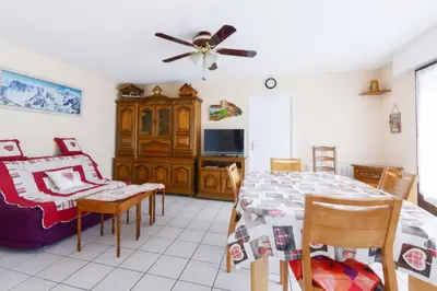 a dining room with a table and a ceiling fan at Appartement Very - Welkeys in Sallanches