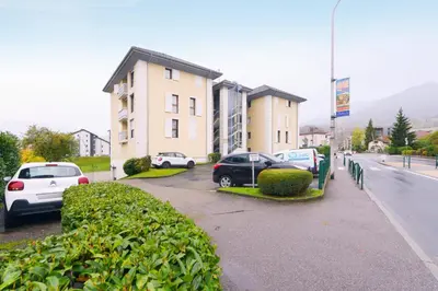 a row of cars parked in front of a building at Appartement Very - Welkeys in Sallanches