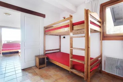 a room with two bunk beds and a window at Résidence Odalys Le Front de Neige in Les Carroz d'Araches