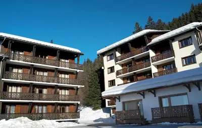 a large building with snow on the ground at Résidence Odalys Le Front de Neige in Les Carroz d'Araches