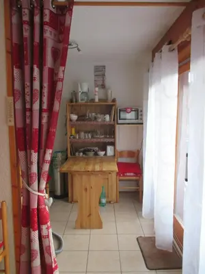 a room with a table and a red curtain at appartement 4 personnes Armancette in Les Contamines-Montjoie