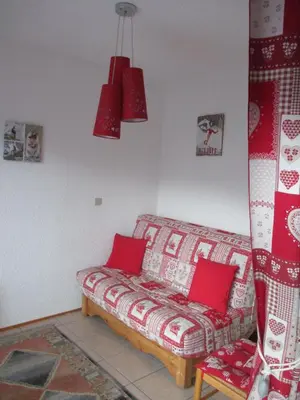 a living room with a couch with red pillows at appartement 4 personnes Armancette in Les Contamines-Montjoie