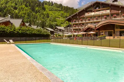 a large swimming pool in front of a hotel at Chalet-Hôtel La Chemenaz in Les Contamines-Montjoie