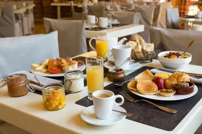 a table with breakfast foods and drinks on it at Chalet-Hôtel La Chemenaz in Les Contamines-Montjoie