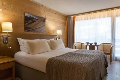 a hotel room with a large bed and a window at Chalet-Hôtel La Chemenaz in Les Contamines-Montjoie