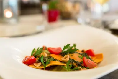 a white plate with a dish of food on a table at Chalet-Hôtel La Chemenaz in Les Contamines-Montjoie