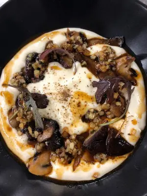 a pizza with mushrooms and onions in a frying pan at Chalet-Hôtel La Chemenaz in Les Contamines-Montjoie