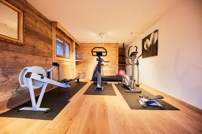 a gym with treadmills and exercise bikes in a room at Chalet-Hôtel Neige et Roc, The Originals Relais in Samoëns