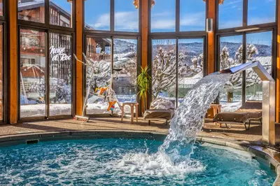 a fountain in a swimming pool in a house at Chalet-Hôtel Neige et Roc, The Originals Relais in Samoëns