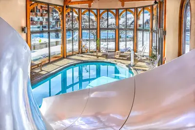 an indoor pool in a building with a slide at Chalet-Hôtel Neige et Roc, The Originals Relais in Samoëns
