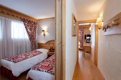 a hotel room with two beds and a window at Chalet-Hôtel Neige et Roc, The Originals Relais in Samoëns