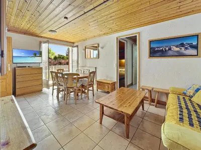 a living room with a bed and a table and chairs at Appartement 5/6 Pers centre Carroz (ARB 40) in Les Carroz d'Araches