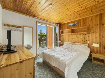 a bedroom with a bed and a desk with a television at Appartement 5/6 Pers centre Carroz (ARB 40) in Les Carroz d'Araches