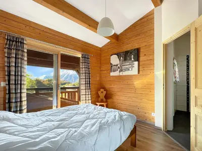 a bedroom with a bed and a large window at Chalet Haut Standing à proximité du centre (CH228) in Les Carroz d'Araches
