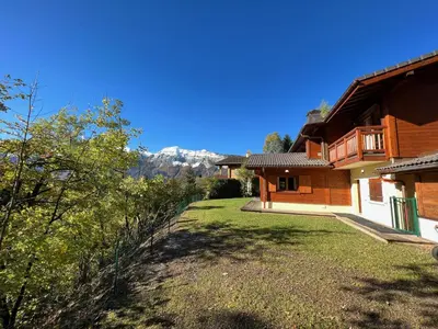 a house with a yard with a mountain in the background at Chalet Haut Standing à proximité du centre (CH228) in Les Carroz d'Araches
