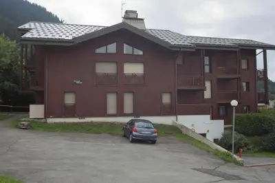 a car parked in front of a large building at Duplex 6/8 Pers Télécabine des Carroz (ES116) in Les Carroz d'Araches
