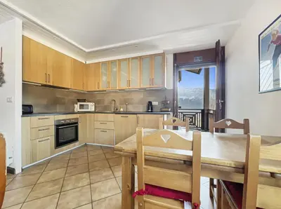 a kitchen with a wooden table and a dining room at Duplex 6/8 Pers Télécabine des Carroz (ES116) in Les Carroz d'Araches