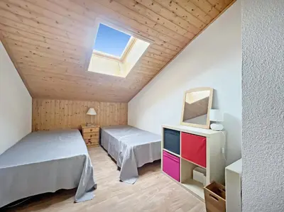 a bedroom with two beds and a skylight at Duplex 6/8 Pers Télécabine des Carroz (ES116) in Les Carroz d'Araches