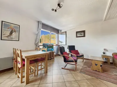 a living room with a wooden table and chairs at Duplex 6/8 Pers Télécabine des Carroz (ES116) in Les Carroz d'Araches