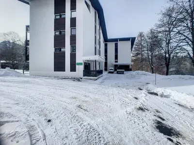 a snow covered road in front of a building at 3 Pièces 6/8 Pers proche centre Carroz (MU0001) in Les Carroz d'Araches