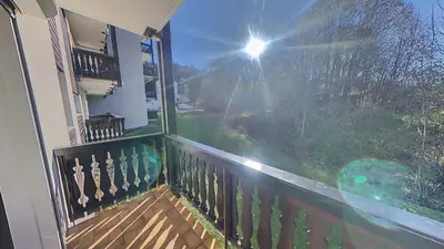 a balcony with the sun shining through a window at 3 Pièces 6/8 Pers proche centre Carroz (MU0001) in Les Carroz d'Araches