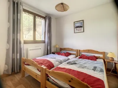 a bedroom with a wooden bed and a window at 3 Pièces 6 Pers proche pistes (PN001) in Les Carroz d'Araches