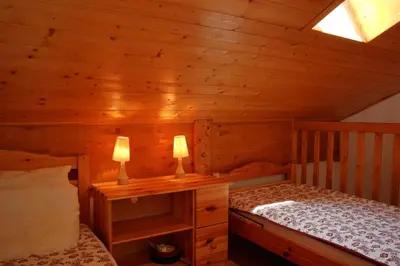 a log cabin bedroom with a bed and two lamps at Duplex 6 Pers centre station Carroz (SA315) in Les Carroz d'Araches
