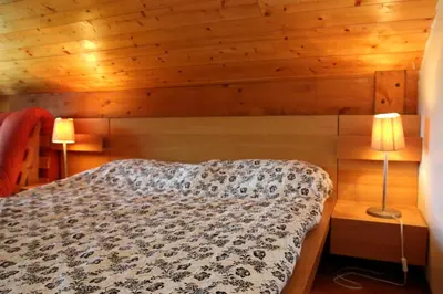 a bedroom with a bed with two lamps in it at Duplex 6 Pers centre station Carroz (SA315) in Les Carroz d'Araches