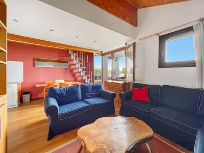 a living room with two blue couches and a table at Duplex 6 Pers centre station Carroz (SA315) in Les Carroz d'Araches