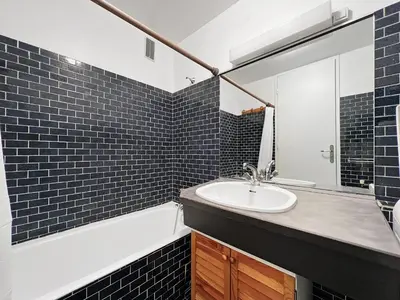 a bathroom with a sink and a mirror and a tub at Duplex 8 Pers centre des Carroz (SL404) in Les Carroz d'Araches