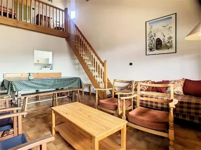 a living room with wooden furniture and a staircase at Duplex 8 Pers centre des Carroz (SL404) in Les Carroz d'Araches