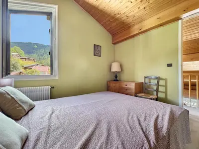 a bedroom with a large bed and a window at Duplex 8 Pers centre des Carroz (SL404) in Les Carroz d'Araches
