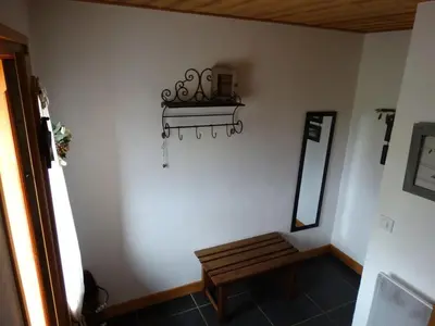 a room with a bench and a mirror on the wall at Appartement cosy à Samoëns avec jacuzzi in Samoëns