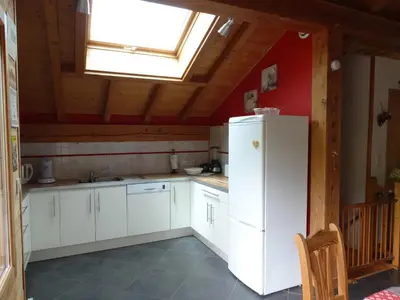 a kitchen with a white refrigerator and a skylight at Appartement cosy à Samoëns avec jacuzzi in Samoëns