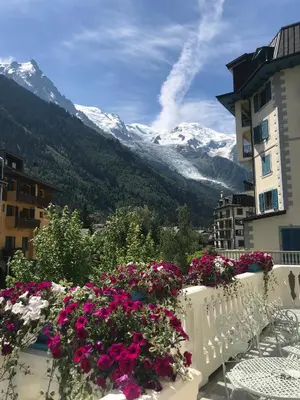 a balcony with flowers and a view of mountains at Grand Hôtel des Alpes in Chamonix-Mont-Blanc
