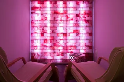 a room with two chairs and a wall with pink lights at Grand Hôtel des Alpes in Chamonix-Mont-Blanc