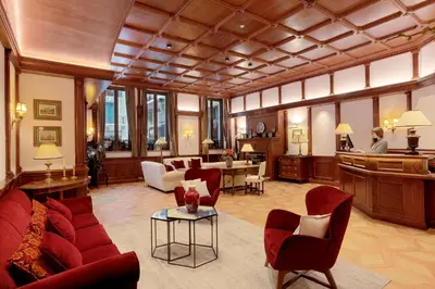 a living room with a red couch and chairs at Grand Hôtel des Alpes in Chamonix-Mont-Blanc