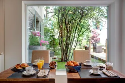 a table with a breakfast of croissants and orange juice at Grand Hôtel des Alpes in Chamonix-Mont-Blanc