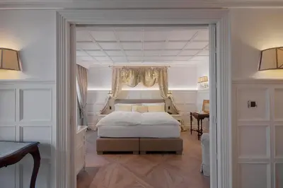 a bedroom with a king sized bed and a window at Grand Hôtel des Alpes in Chamonix-Mont-Blanc