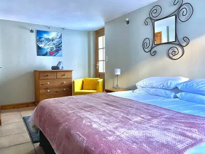a bedroom with a large bed and a yellow chair at The Castle, 10 Bedroom Chalet, Chamonix Centre in Chamonix-Mont-Blanc