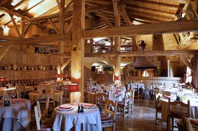 a dining room with tables and chairs in a building at Les Fermes de Marie in Megève
