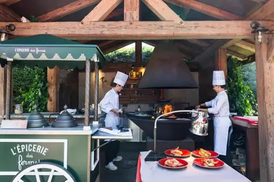 two chefs in a kitchen with food on a table at Les Fermes de Marie in Megève