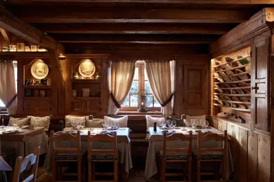 a dining room with tables and chairs and a window at Les Fermes de Marie in Megève