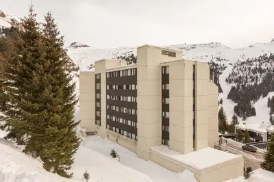 a building in the snow next to a tree at Residence La Foret - maeva Home in Arâches-la-Frasse