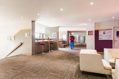 a person standing in a room with a lobby at Residence La Foret - maeva Home in Arâches-la-Frasse