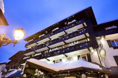 a building with a snow covered bench in front of it at Hotel Mont Blanc Megève in Megève