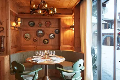 a dining room with a table and chairs at Hotel Mont Blanc Megève in Megève